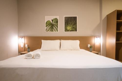 a bedroom with a large white bed with two towels at Marezzi Hotel Aracaju in Aracaju