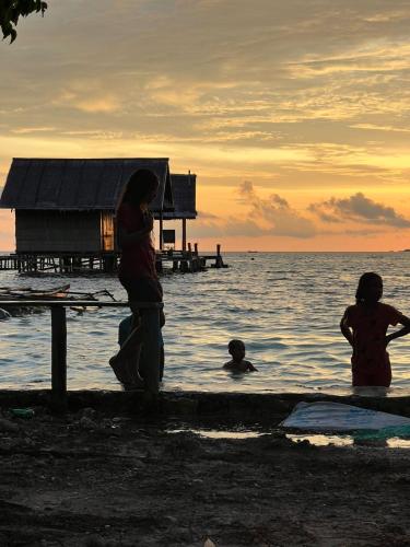 a group of people standing in the water at Indos Homestay-Raja Ampat in Besir