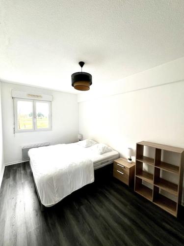 une chambre blanche avec un lit et une fenêtre dans l'établissement Aigues Marines - Appartement spacieux avec parking et terrasse, à Aytré