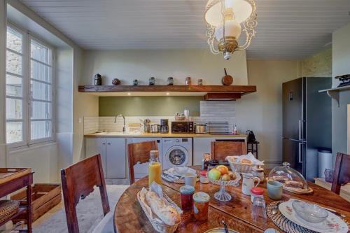 a kitchen with a wooden table with food on it at Gîte de charme avec piscine dans le Gers « Le Clos Boissière » in Valence-sur-Baïse