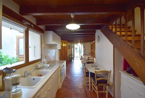 eine Küche mit Spüle und Tisch mit Stühlen in der Unterkunft Agréable maison de ville in Agen