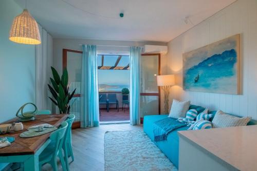 een woonkamer met een blauwe bank en een tafel bij Pandora Sea View by Solturelba in Capoliveri
