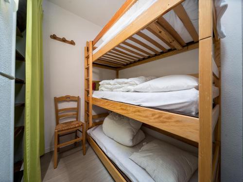 Cette chambre dispose de lits superposés avec 2 lits superposés et une chaise. dans l'établissement T de la Foux N 51 - 2P5C, à Allos