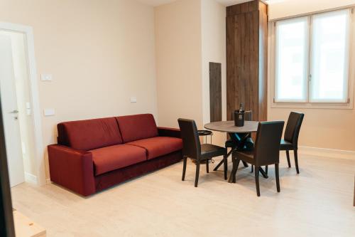 a living room with a red couch and a table at Wine & Wellness in Villalta