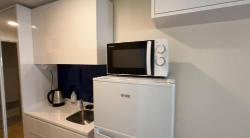 a microwave on top of a refrigerator in a kitchen at Orbi City D2 in Batumi