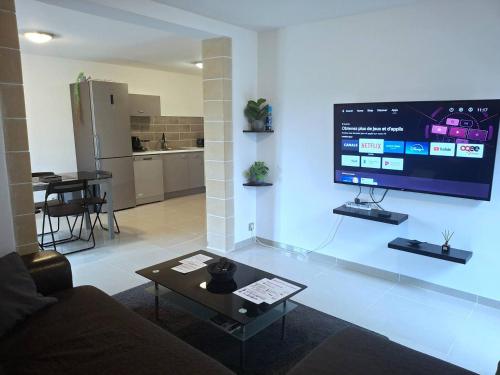 a living room with a couch and a tv on a wall at Appartement Villeneuve in Villeneuve-de-Blaye