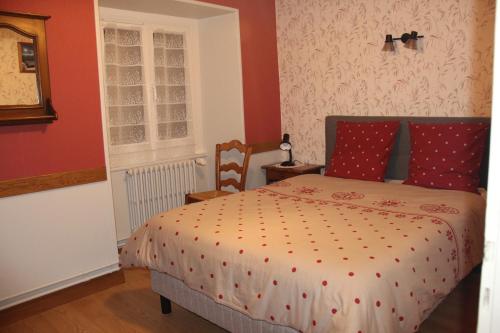 a bedroom with a bed with red walls at Chez Gilles et Christine in Mieussy
