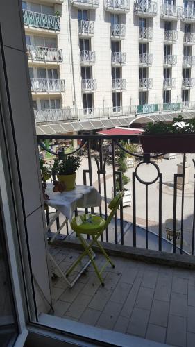 une table et une chaise sur un balcon avec vue sur un immeuble dans l'établissement Charming Studio near Paris, à Montrouge