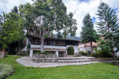 a house with a tree in the yard at La Cabaña del Abuelo in Lourdes