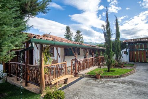 a house with a wooden fence and a porch at La Cabaña del Abuelo in Lourdes
