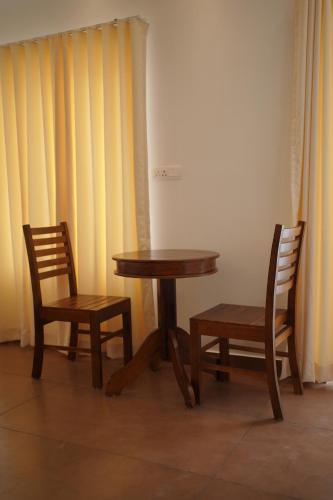 two chairs and a table and a table and two chairs at Golden Sands Cherai in Cherai Beach