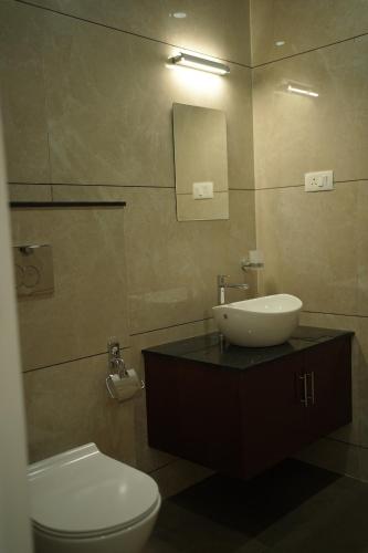 a bathroom with a sink and a toilet and a mirror at Golden Sands Cherai in Cherai Beach
