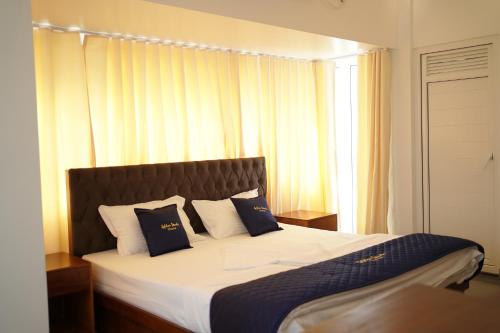 a bedroom with a large bed with blue and white pillows at Golden Sands Cherai in Cherai Beach