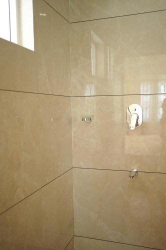 a shower stall with a shower head on the wall at Golden Sands Cherai in Cherai Beach