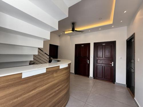 a kitchen with a counter and two brown doors at Golden Sands Cherai in Cherai Beach