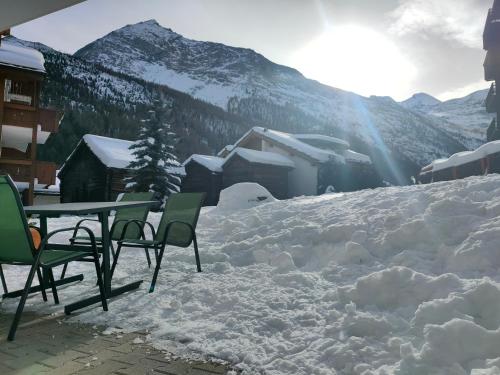 a table and chairs sitting in the snow at Studio au pied de la télécabine, SaastalCards Saas-Fee in Saas-Fee