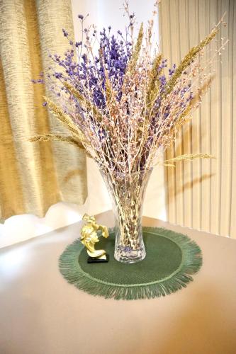 a vase filled with purple flowers on a table at Marilao Bulacan VIP flat in Lias