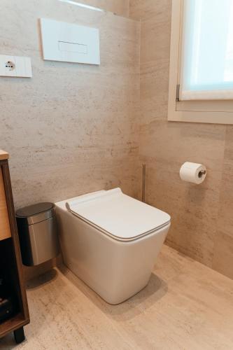 a bathroom with a white toilet and a window at Wine & Wellness in Villalta