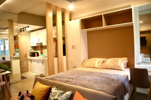 a bedroom with a large bed and a kitchen at Marilao Bulacan VIP flat in Lias