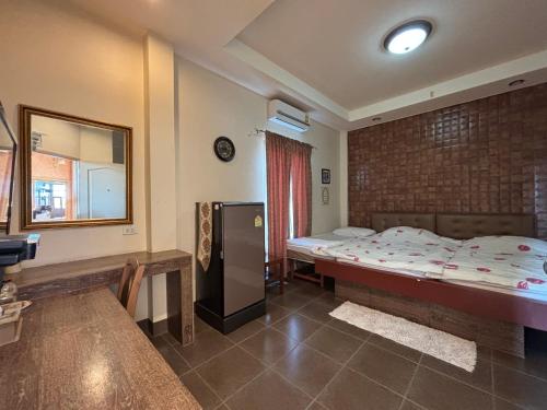 a bedroom with a bed and a table and a mirror at Kireeya Villa in Phetchaburi