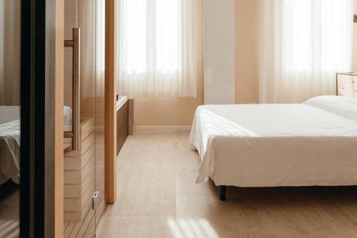 a small bedroom with a bed and a mirror at Wine & Wellness in Villalta