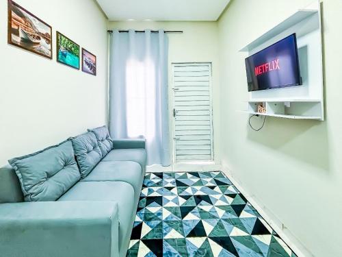 a living room with a blue couch and a tv at Vila Imper Host Itz - Apês com Wi-fi I A/C a 5 min. do Imperial Shopping in Imperatriz
