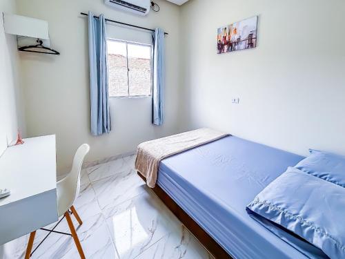 a bedroom with a bed and a desk and a window at Vila Imper Host Itz - Apês com Wi-fi I A/C a 5 min. do Imperial Shopping in Imperatriz