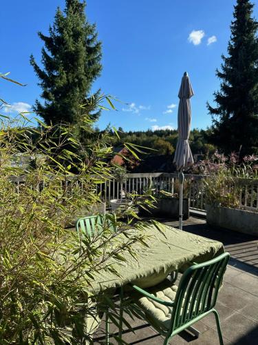 a patio with a table and an umbrella and a bench at B&B Amsel und Meise - privates Zimmer mit Gemeinschaftsräumen in Suhr
