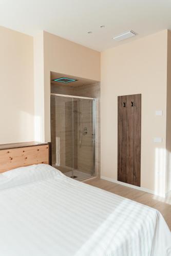 a bedroom with a white bed and a shower at Wine & Wellness in Villalta