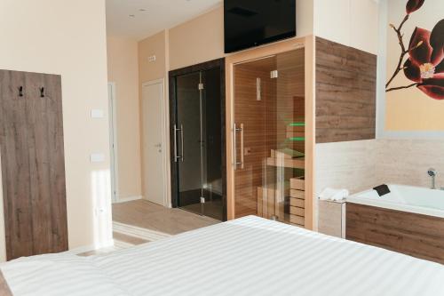 a bedroom with a bed and a tub and a sink at Wine & Wellness in Villalta