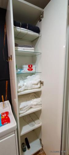 a closet filled with white towels and a shelf at Sweet Home in Dimona