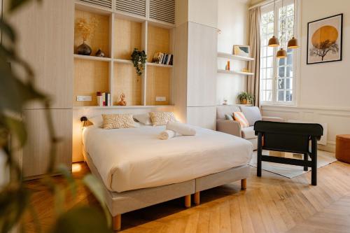a bedroom with a bed and a chair in it at CENTRAL Hôtel La Rochelle Centre in La Rochelle