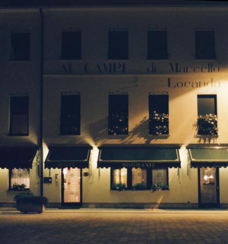 a building with a sign on the side of it at Ai Campi Di Marcello Hotel in Monfalcone