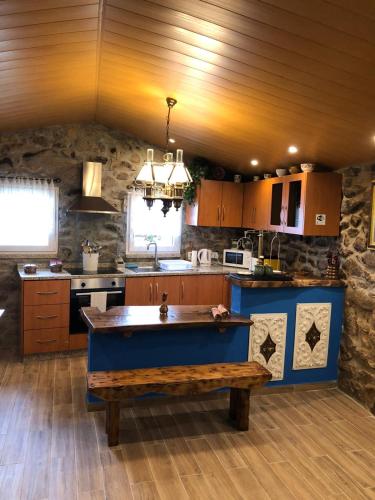 a kitchen with a blue island in the middle at Casas do Lobo in Tarouca