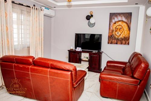 a living room with a couch and a television at Royal Hillside Apartments and Hotels in Yaoundé