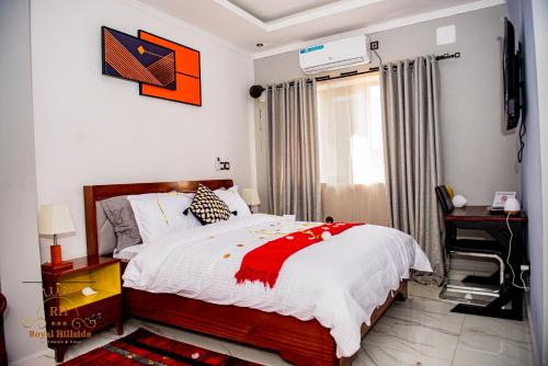 a bedroom with a bed and a desk and a window at Royal Hillside Apartments and Hotels in Yaoundé