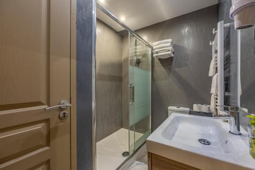 a bathroom with a sink and a glass shower at LOGIS DU GRAND PIN in Saint-Martin-des-Entrées
