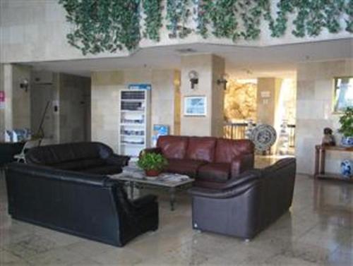 a living room with two leather couches and a table at Tumon Bay Capital Hotel in Tumon
