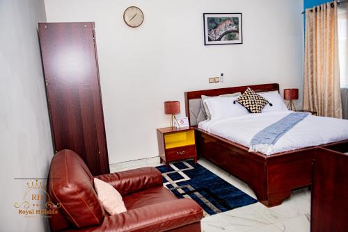 a bedroom with a bed and a couch and a chair at Royal Hillside Apartments and Hotels in Yaoundé