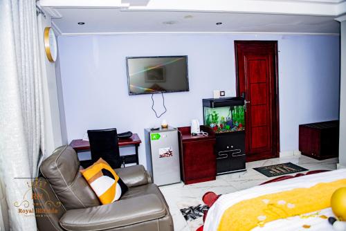 a room with a bed and a tv and a couch at Royal Hillside Apartments and Hotels in Yaoundé