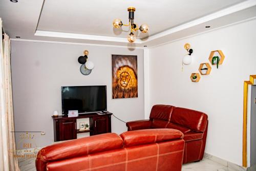 a living room with a couch and a television at Royal Hillside Apartments and Hotels in Yaoundé