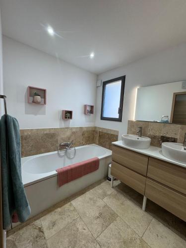 une salle de bain avec deux lavabos, une baignoire et un miroir dans l'établissement VILLA Écrin de SAZE - LUXE & SPA, à Saze