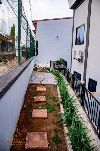 a garden with rocks and plants next to a building at Royal Hillside Apartments and Hotels in Yaoundé