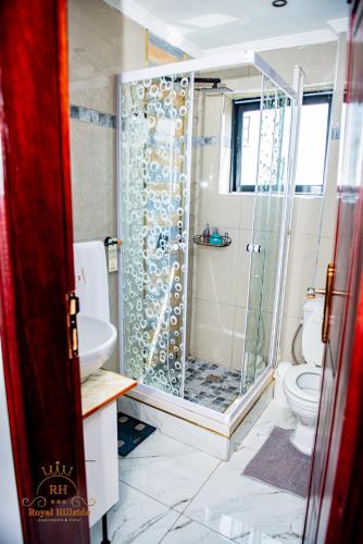 a bathroom with a shower and a toilet at Royal Hillside Apartments and Hotels in Yaoundé