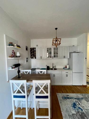 una cucina con mobili bianchi e un frigorifero bianco di G4 Apartment a Ulcinj