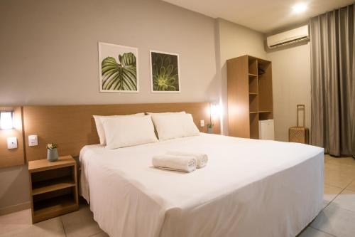 a bedroom with a large white bed with towels on it at Marezzi Hotel Aracaju in Aracaju