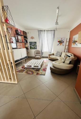 a living room with two couches and a staircase at Chez Hélène et Jérémy in Montargis