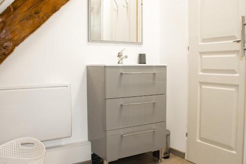 une salle de bain avec un lavabo et un miroir dans l'établissement Charmant gîte en pierres, à Saint-Jean-de Laurs