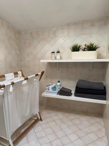 a bathroom with white shelves with towels and plants at A casa di zia Maly in Palena