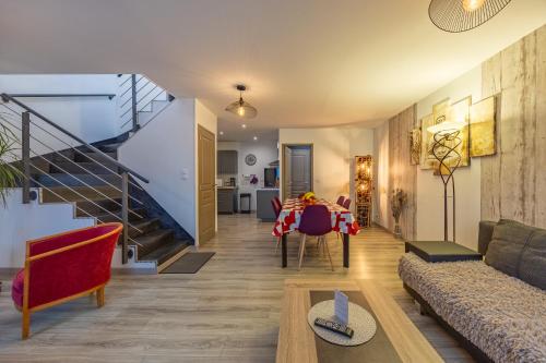 a living room with a staircase and a table at LOGIS DU GRAND PIN in Saint-Martin-des-Entrées